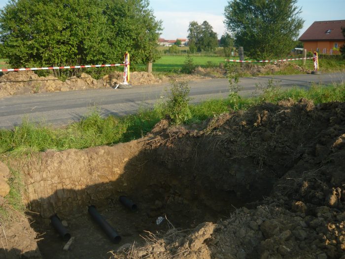 Příprava pro vedení kabelů nízkého napětí pod silnicí na nové parcely (24.8.2011)